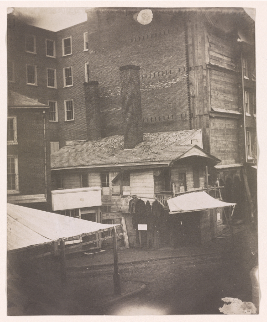 old black and white photo of a rundown rowhouse